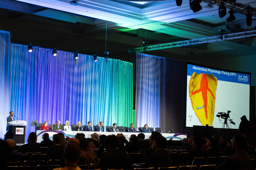 Experts participate in a Heart Rhythm 2025 panel session while a detailed cardiac imaging slide is projected behind them