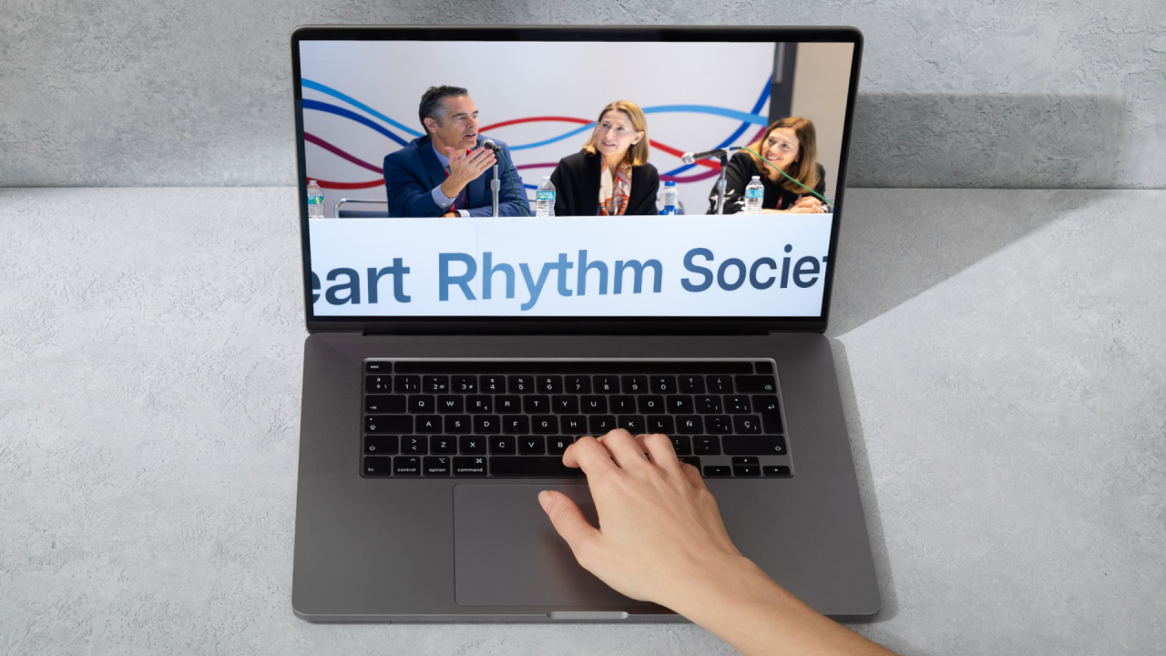 Three panelists seated at a Heart Rhythm Society conference table, displayed on a laptop screen